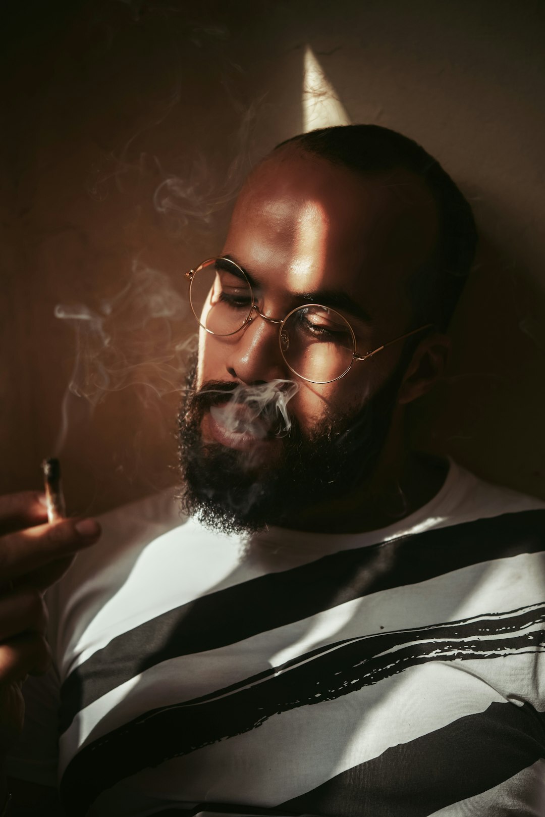 Studio portrait of a bearded man in his 40s wearing glasses