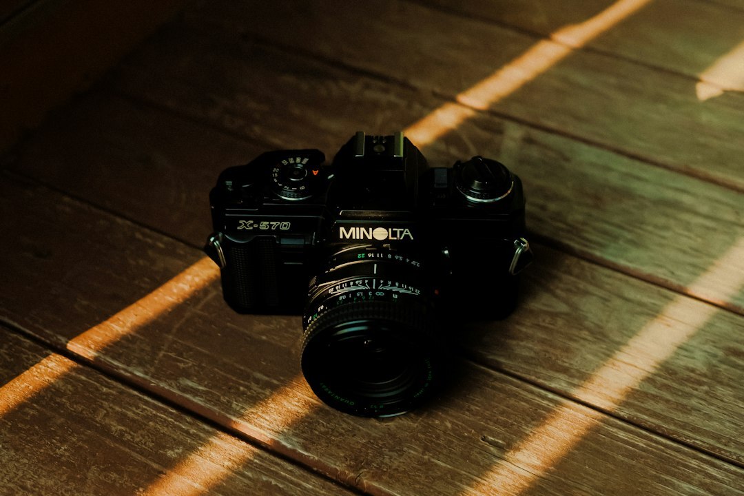 Vintage camera resting on a wooden surface with soft light
